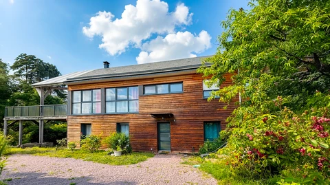 Maison contemporaine à bardage bois horizontal en cèdre, deux niveaux, toiture asymétrique en bardeau bitumineux avec cheminée métallique