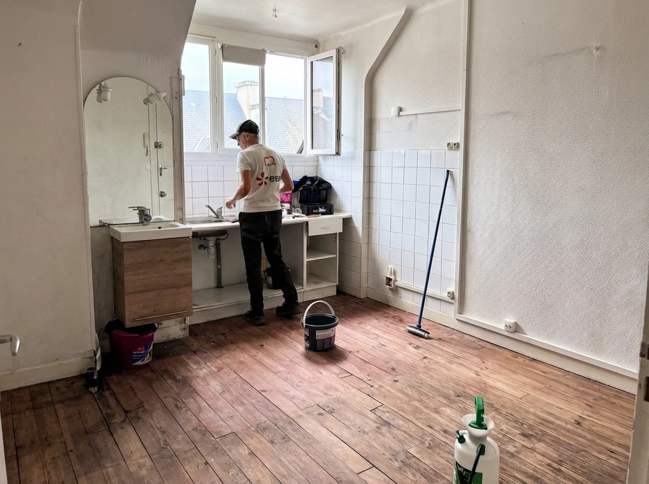 Un homme souriant en tablier beige et chemise à carreaux sélectionne un outil dans un magasin de bricolage